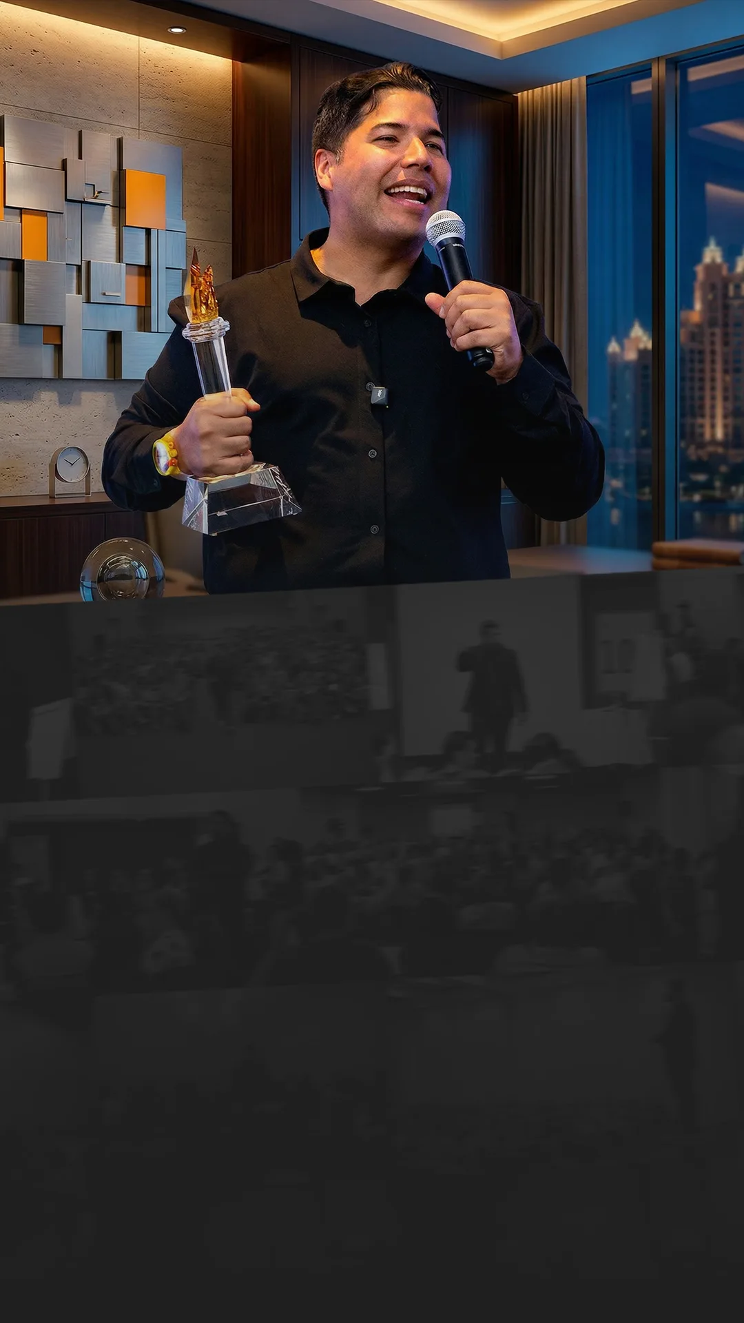 JManta dando una conferencia, sosteniendo un trofeo y un micrófono